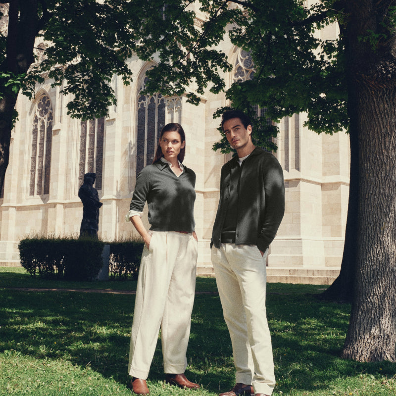 Female and male model wearing N.Peal cashmere under a tree in Vienna